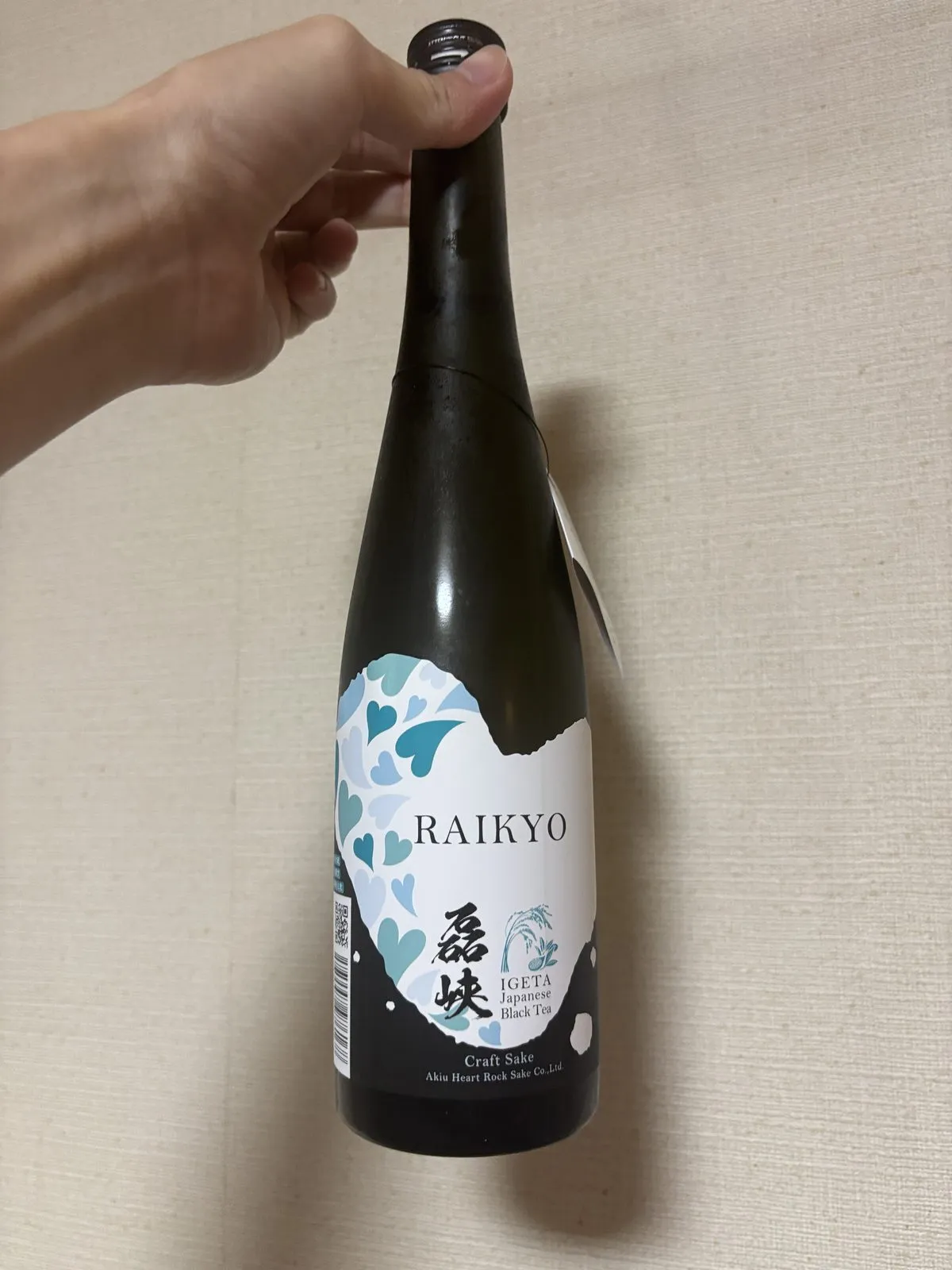 磊峡 和紅茶のボトル。黒い瓶に、青いハートが波のように散ったラベル