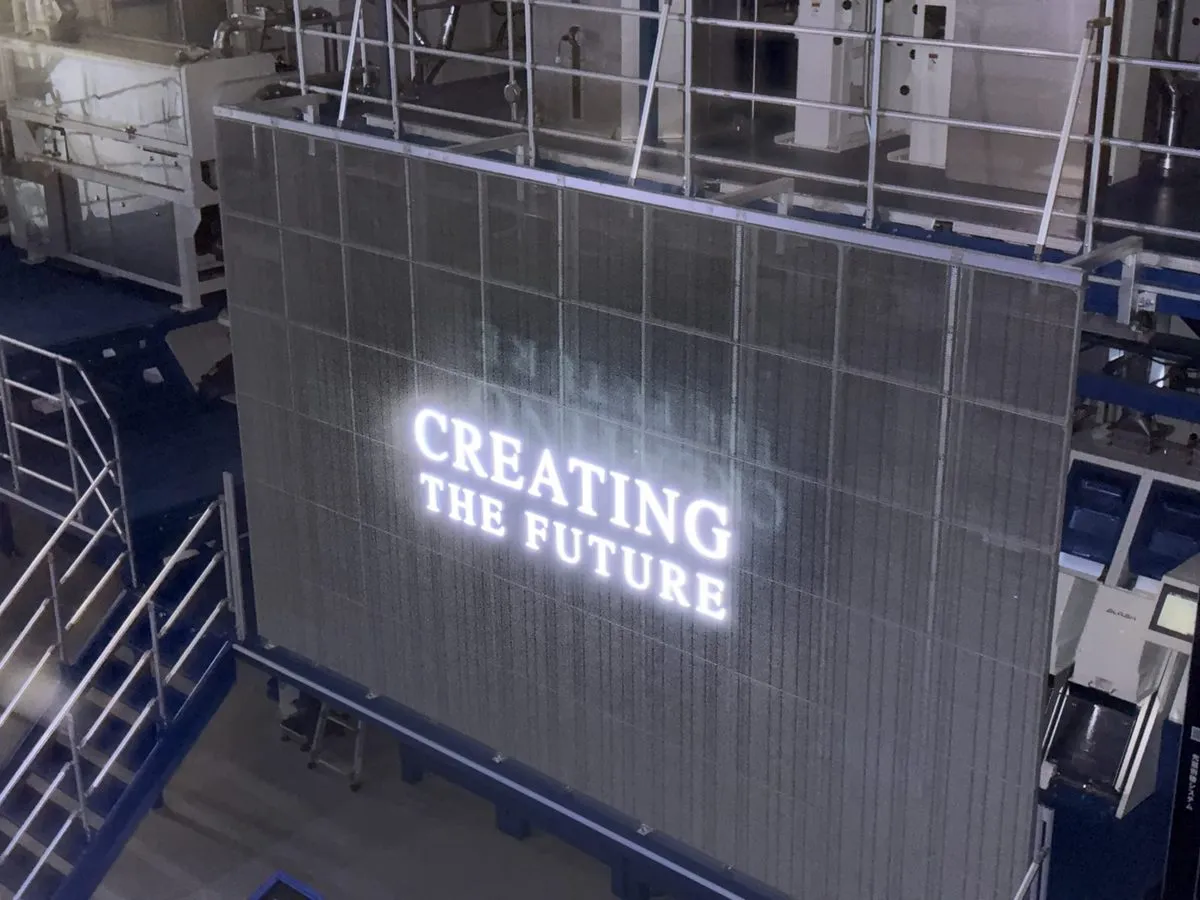 暗い館内のスクリーンに「CREATING THE FUTURE」の白い文字が浮かぶ